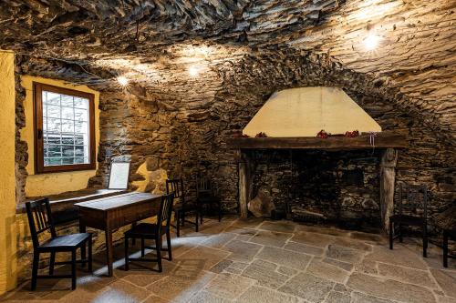 a stone room with a table and a fireplace at Dimora Storica Casa Vanni in Villadossola