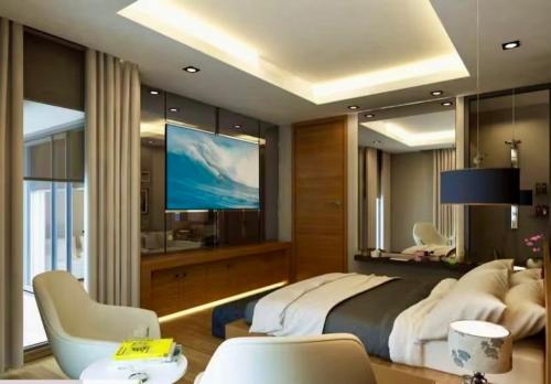a bedroom with a large bed and a flat screen tv at Hotel Ambrosia in Bitez