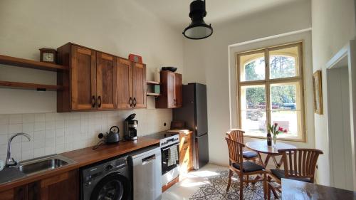 a kitchen with a dishwasher and a table with chairs at Villa Lobkovice: Gemütliches Gästehaus am Schloss in Lobkovice