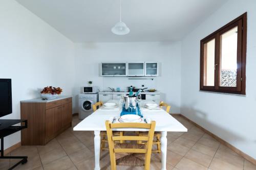 a kitchen with a white table and two chairs at Residence I Mirti in Porto Pozzo
