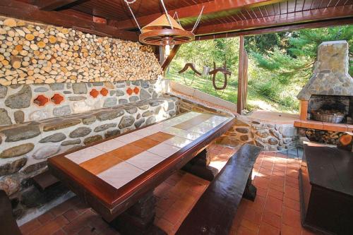 a room with a stone wall with a wooden bench at Bonidesa House With Whirlpool - Happy Rentals in Ljubno