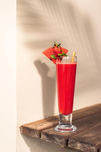 a red drink with a strawberry in a glass at Khla Lodge in Kampot