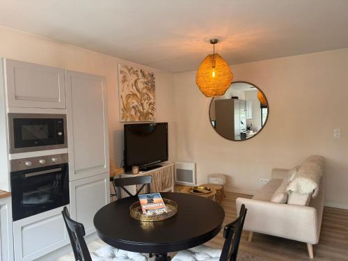 un salon avec une table et une télévision dans l'établissement Maison + parking privé au Cœur Angoulême 60m2, à Angoulême