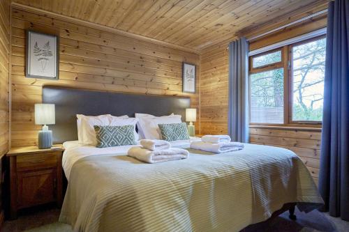 ein Schlafzimmer mit einem Bett mit Handtüchern darauf in der Unterkunft Dunnock Lodge with Hot-tub in Carlisle