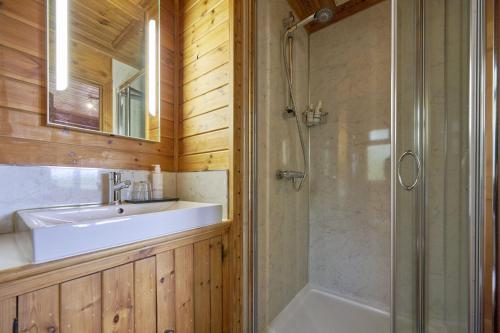 a bathroom with a sink and a shower at Dunnock Lodge with Hot-tub in Carlisle