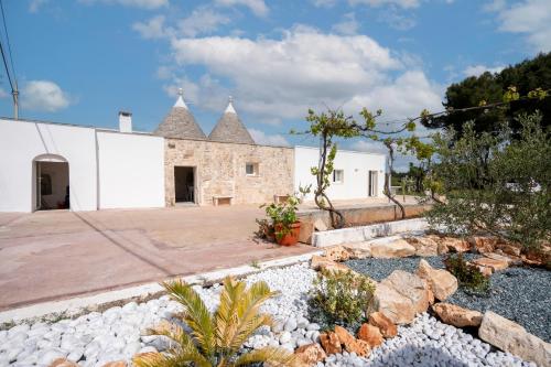 a stone house with a courtyard with rocks at Trulli Miriam: Enchanting Apulian Getaway in Martina Franca