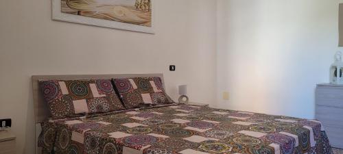 1 cama con edredón y almohadas en un dormitorio en Casa Nonno Luigi, en Montesano Salentino
