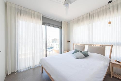 a bedroom with a white bed and a large window at PORT CITY HAIFA - Luxury Seaview Penthouse w Jaccuzzi in Haifa