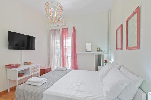 1 dormitorio blanco con 1 cama y TV en Faliron Urban Retreat, en Atenas