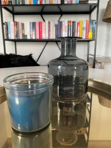 a candle and a glass vase on a table at Guesthouse The White House - gehele huisje in Klaaswaal