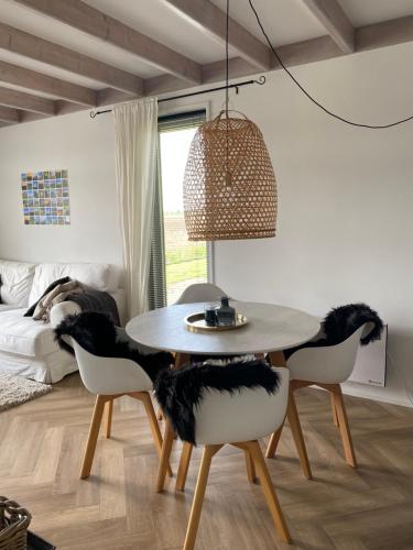 a dining room with a table and four chairs at Guesthouse The White House - gehele huisje in Klaaswaal