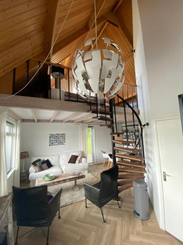 uma sala de estar com uma escada em espiral numa casa em Guesthouse The White House em Klaaswaal