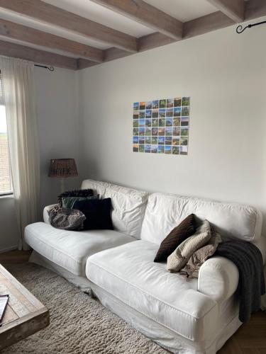 a white couch sitting in a living room at Guesthouse The White House - gehele huisje in Klaaswaal