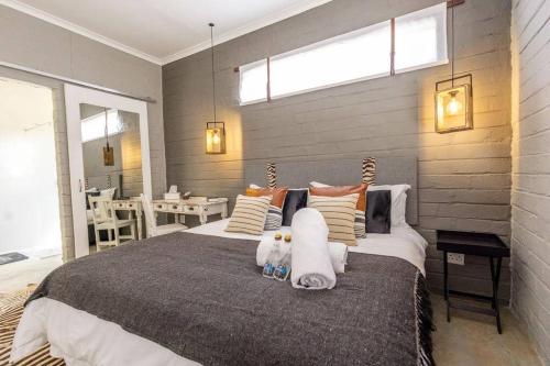 a bedroom with a large bed with two stuffed animals on it at Amara Self Catering in Otjiwarongo