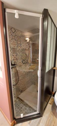uma porta de vidro de um chuveiro na casa de banho em L'OAZIS em Malissard