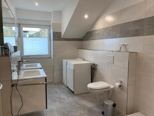 ein Badezimmer mit Toilette und Waschbecken und einem Fenster in der Unterkunft Amselstern Binz in Binz