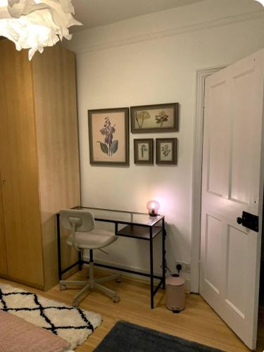 Camera con scrivania, sedia e lampadario pendente. di Kenwood Gem a Edmonton