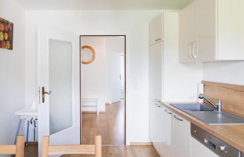 a kitchen with white cabinets and a sink at Familytime am Traunsee in Altmünster