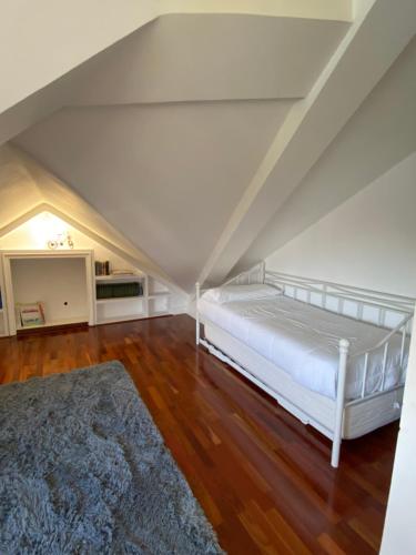 a bedroom with a white bed and a rug at Chalet con Piscina Privada in Santander