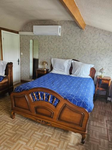 een slaapkamer met een groot bed en een blauw dekbed bij Gîte de Montapeine in Breteau