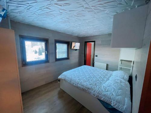 a bedroom with a bed and a ceiling with at Biancaneve - 300 Metri dalle Piste, Free Parking e Wi-Fi in Passo del Tonale