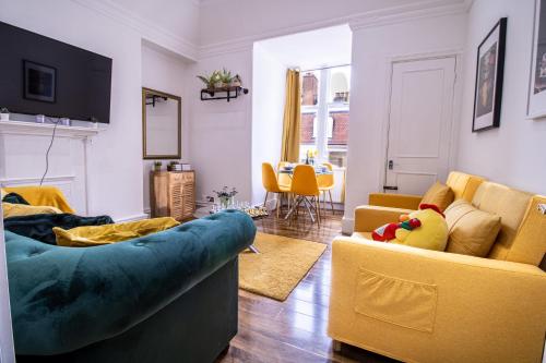 - un salon avec un canapé bleu et des fauteuils jaunes dans l'établissement Luxurious Apartments on Oxford Street, à Londres