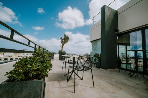 a patio with tables and chairs on the roof of a building at Park Heights by the Warren Collection in Msida