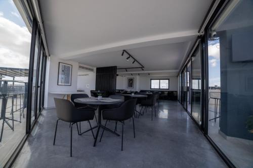 a dining room with tables and chairs and windows at Park Heights by the Warren Collection in Msida