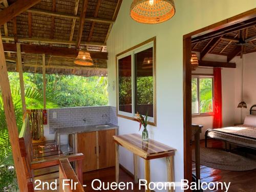 a room with a kitchen and an open room balcony at Wayans Siargao in General Luna