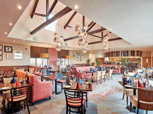a restaurant with tables and chairs in a room at Mallard Cottage Lake District, Leisure Spa Pool & Gym in Penruddock