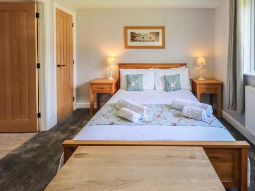 a bedroom with a large bed with two night stands at Mallard Cottage Lake District, Leisure Spa Pool & Gym in Penruddock
