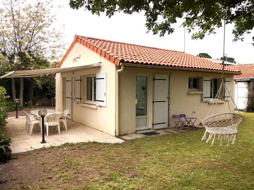a small house with a porch and a swing at La Palaine, maison à 150m de la mer in La Plaine-sur-Mer