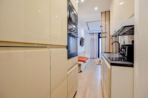 une cuisine avec des armoires blanches et un évier dans l'établissement Relax in a Stylish Flat in Montmartre, à Paris