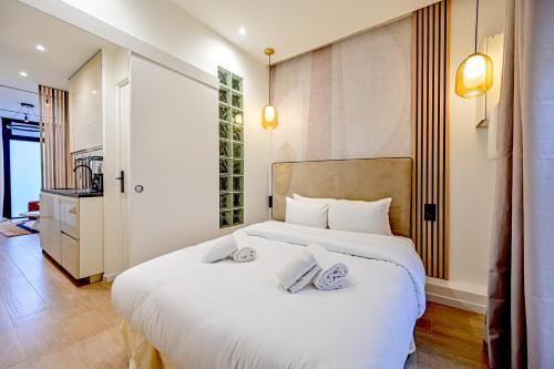 une chambre avec un grand lit blanc avec deux oreillers dans l'établissement Relax in a Stylish Flat in Montmartre, à Paris