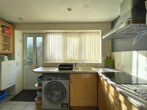 uma cozinha com uma máquina de lavar roupa e um lavatório em Sheffield's 3BR Retreat em Hillsborough