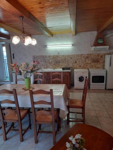 une cuisine avec une table et des chaises ainsi qu'une cuisine avec une cuisinière dans l'établissement gite proche du mt st michel, à Courtils