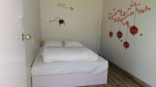 a small bedroom with a white bed with red accents at IInfinity Kodaikanal in Kūkkāl