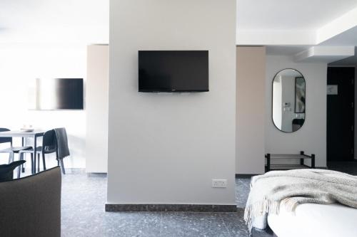 a bedroom with a tv on a wall with a table at Park Heights by the Warren Collection in Msida
