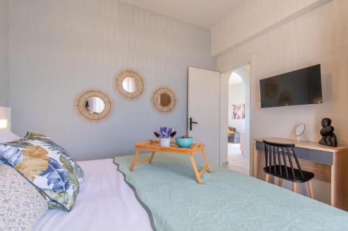 a bedroom with a bed with a table and mirrors at Grande Terra in Kiotari