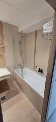 un baño con bañera y ducha en Camera de Inchiriat in Rin Grand Hotel, en Bucarest