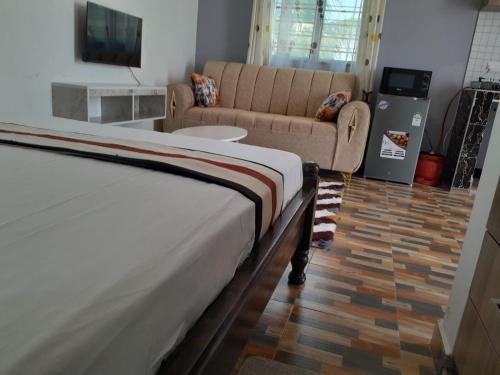 a bedroom with a bed and a couch at Kelly Homes in Kilifi