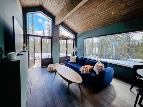 ein Wohnzimmer mit einem blauen Sofa und einem Tisch in der Unterkunft Cozy Mountain Cottage with beautiful views & Sauna in Beitostøl