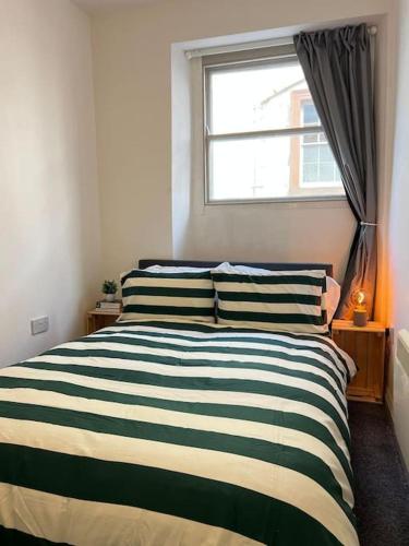 a bedroom with a black and white bed with a window at Little Dockray One-Bed Apartment Centre of Penrith in Penrith
