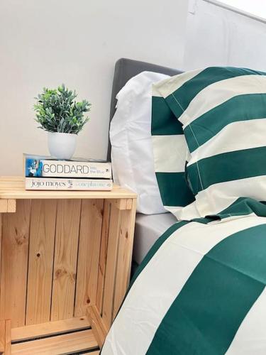 a bed with a plant on top of a wooden table at Little Dockray One-Bed Apartment Centre of Penrith in Penrith