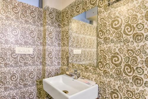 y baño con lavabo y espejo. en Mount Amara Hotel & Spa, Siliguri en Siliguri