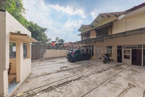 a car parked in a parking lot next to a building at Wisma Alamanda near Terminal Cicaheum RedPartner in Bandung