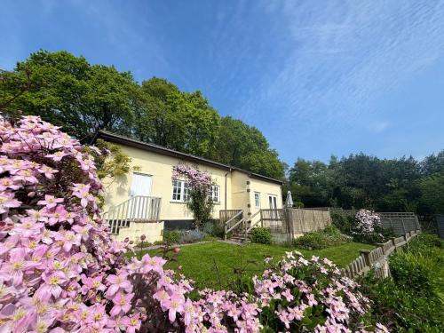 a house with pink flowers in front of it at Oak Tree Cottage in Lydney