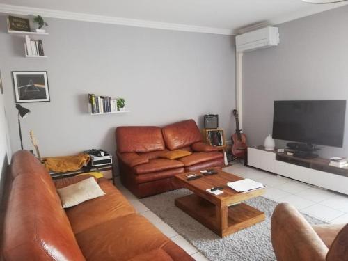 - un salon avec un canapé en cuir et une table basse dans l'établissement Appartement 3 chambres - 2 salles de bain - 6 personnes, à Ajaccio