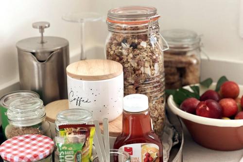 a counter with jars of nuts and a bowl of apples at Gardeners' Cottage in Hamilton