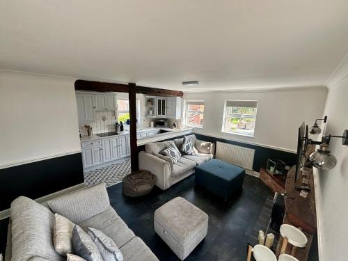 a living room with a couch and a kitchen at THE GARDEN SUITE in Denby